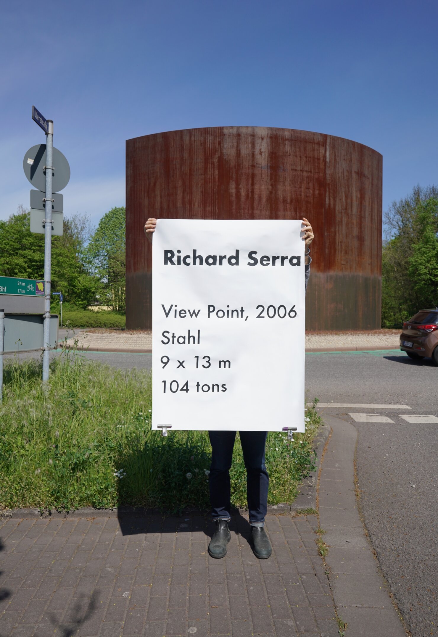 Matthieu Martin, Kreisverkehr, performance with monumental label near public sculpture, Dillingen, 2026